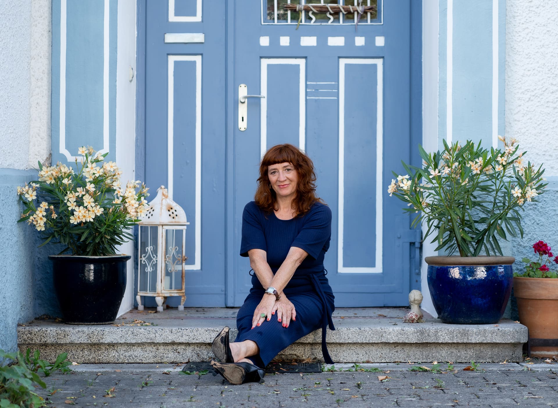 Alexandra sitzt vor Haustüre